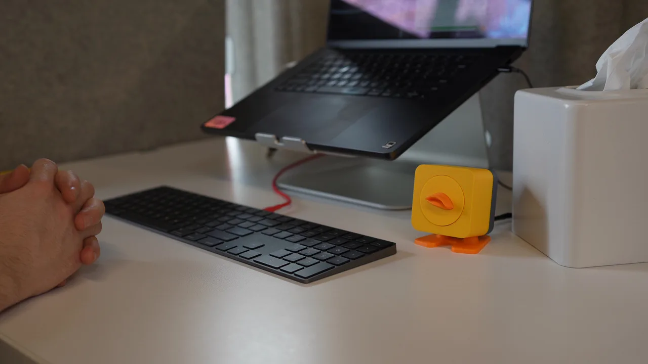 Duck Duck Duck sitting on a desk next to a laptop and keyboard